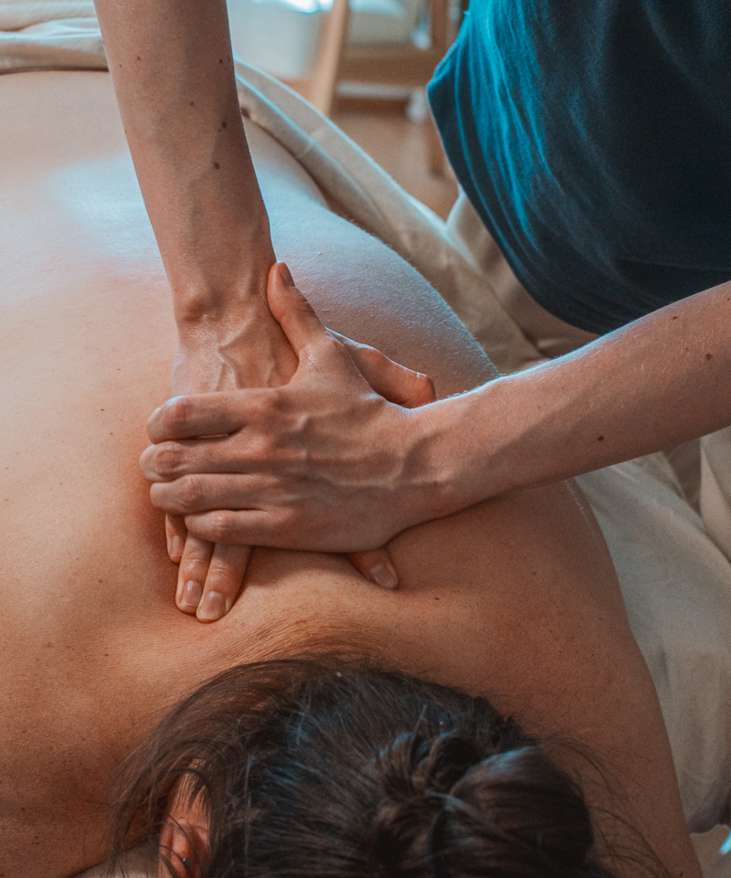 Behandler gir massasje i øvre del av ryggen hos KM Medical